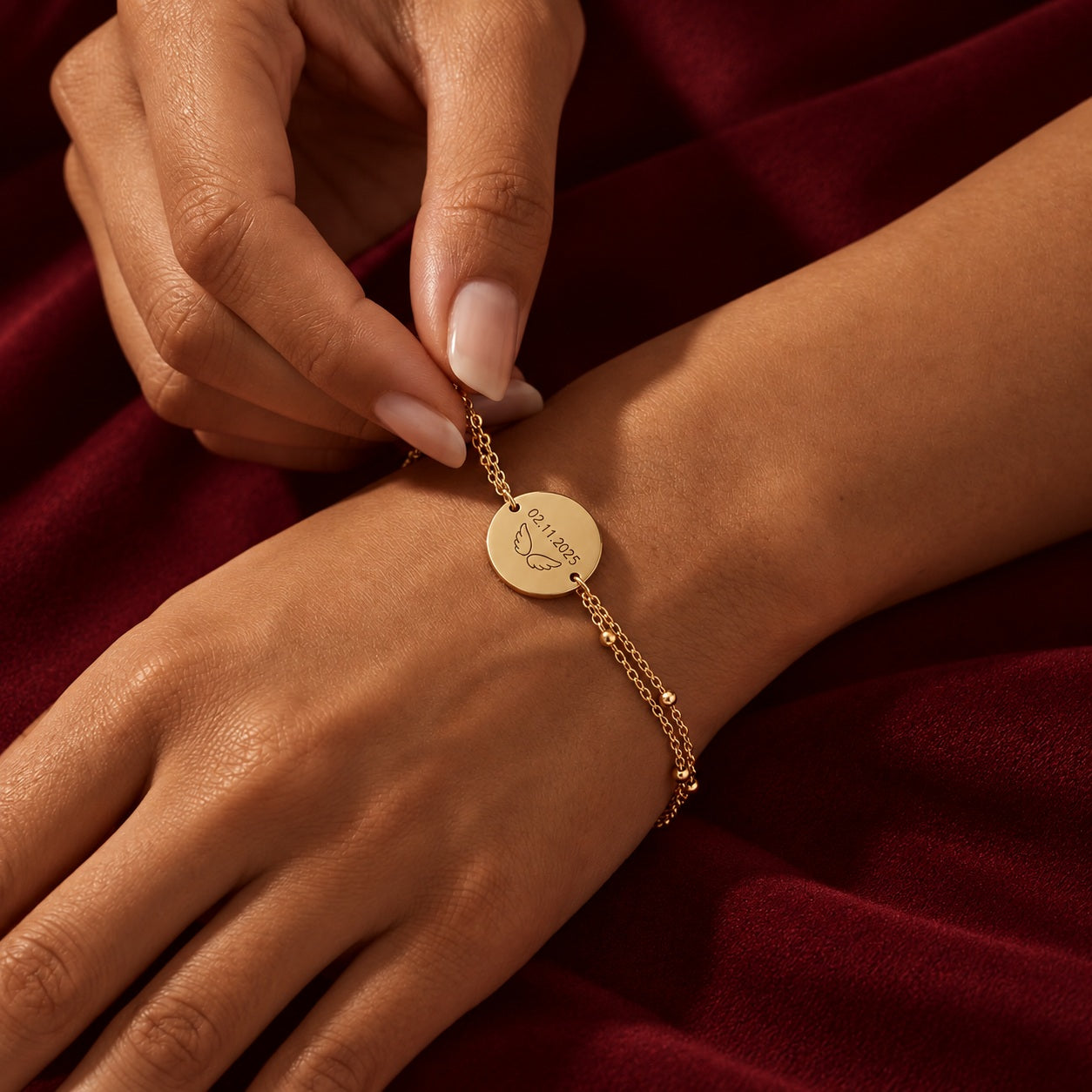 Bracelet personnalisé doré porté sur velours bordeaux
